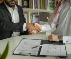 a lawyer and client shaking hands over a document