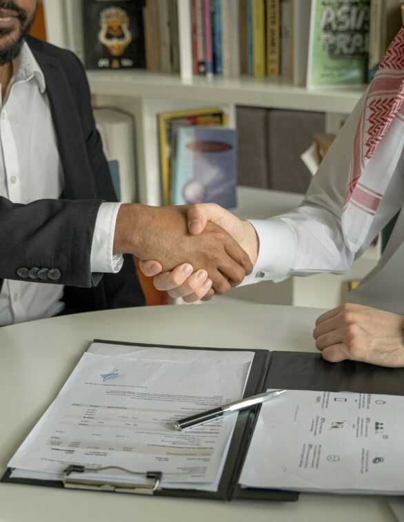 a lawyer and client shaking hands over a document