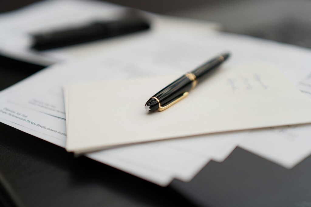 a fountain pen resting on a stack of documents