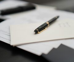 a fountain pen resting on a stack of documents