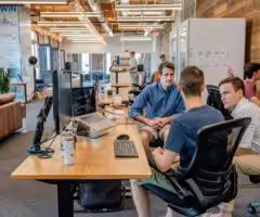 men grouped around a desk having a conversation