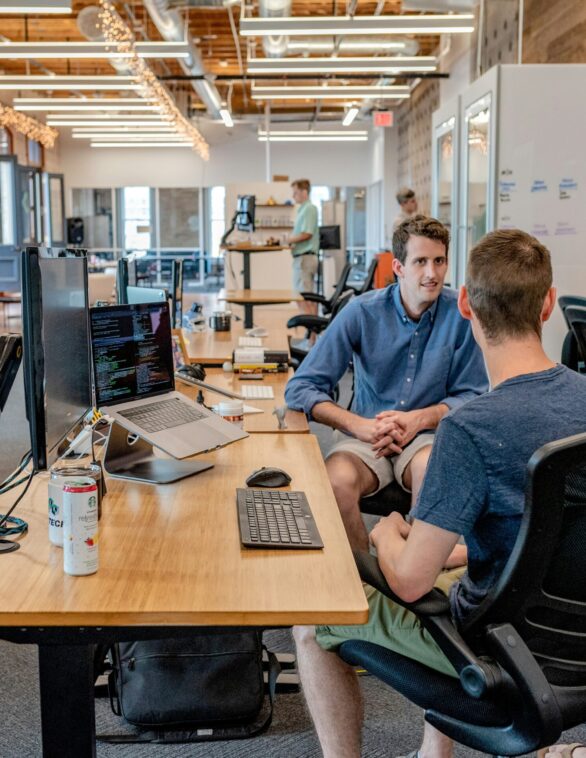 men grouped around a desk having a conversation