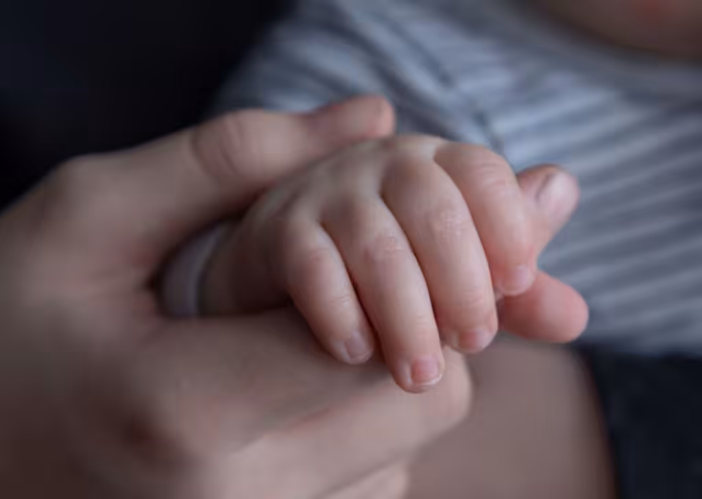 a hand holding a childs hand