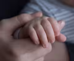 a hand holding a childs hand