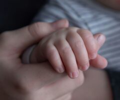 a hand holding a childs hand