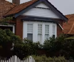image of a house behind some bushes