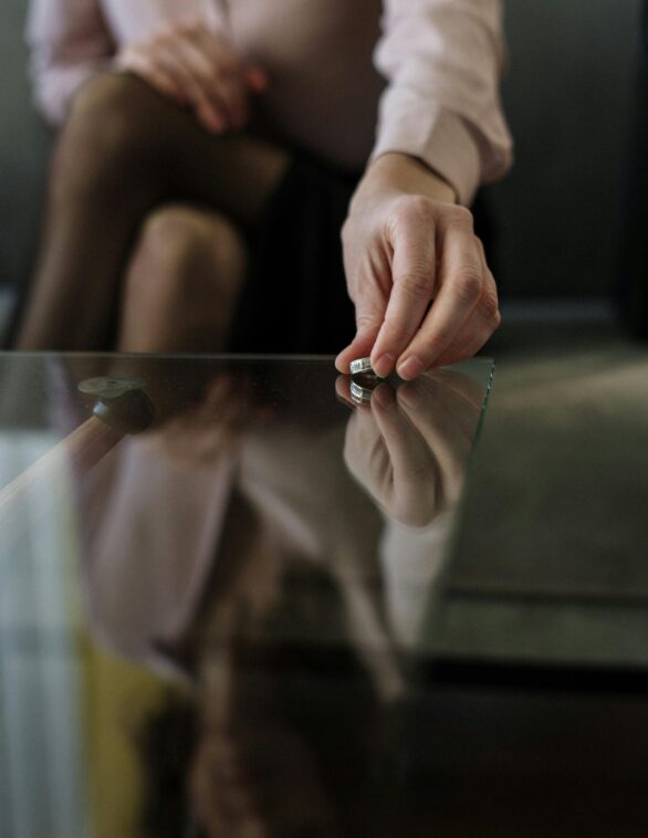 woman placing her ring on a coffee table
