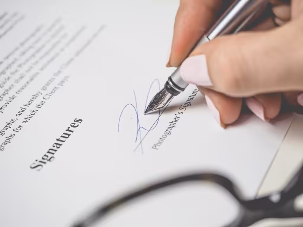 a hand signing a document