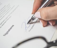 a hand signing a document
