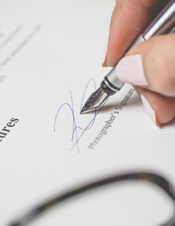a hand signing a document