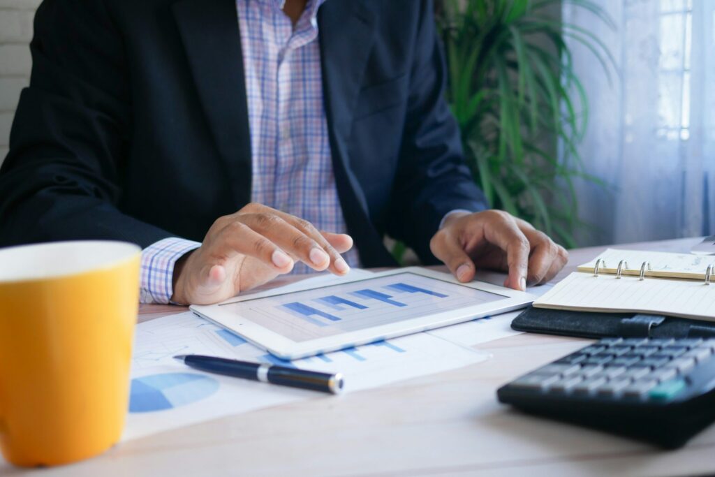 person working at a desk with calculator and financial charts