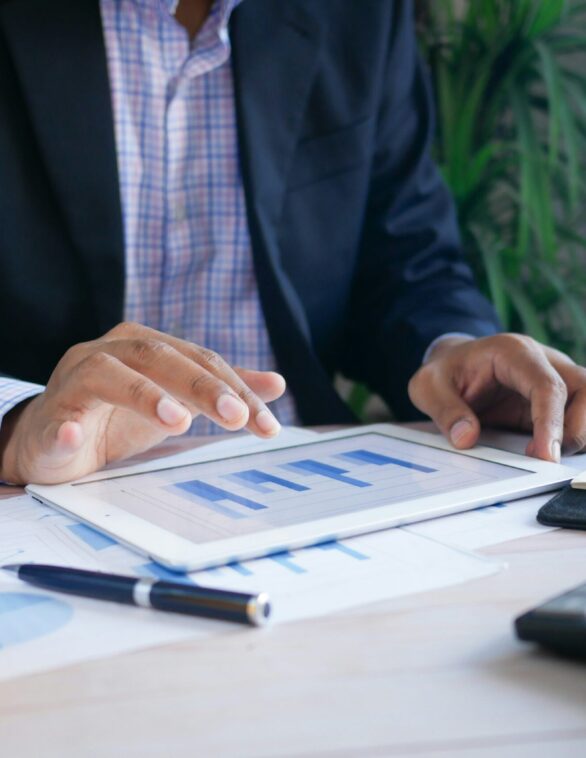 person working at a desk with calculator and financial charts