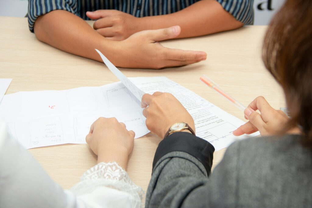 close up on peoples hands and documents on a table